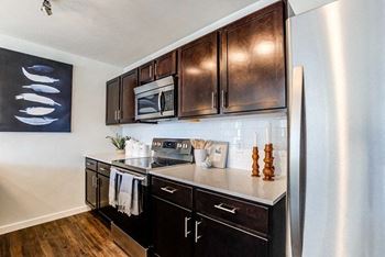 kitchen with dark cabinets and quartz countertops at Connect at First Creek, CO 80249
